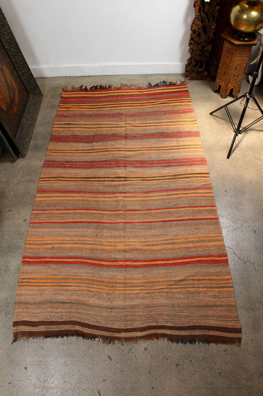 Light handwoven Moroccan vintage tribal rug. Earth colors of browns, oranges and reds stripes. Kilim style flat-weave, very light, great to use for an outdoor terrace, or on grass for picnic.