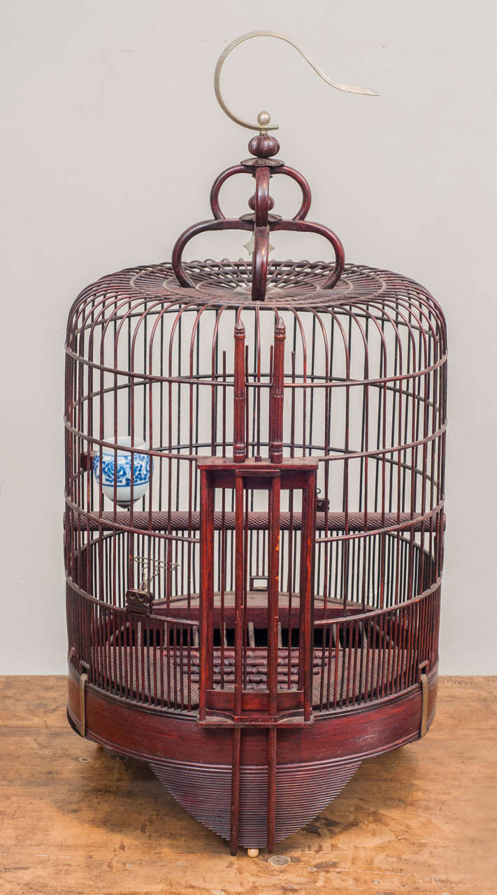 Sculptural, intricately constructed birdcage, traditionally used for cherished songbirds in China.