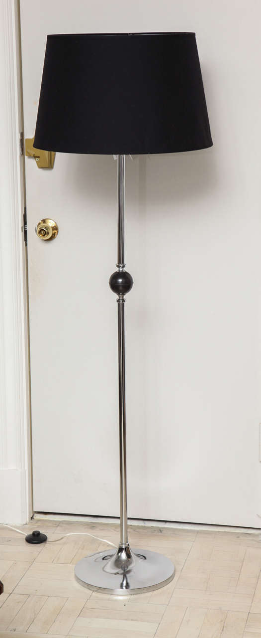 Mid-20th century polished chrome floor lamp, black ball in middle, round base.