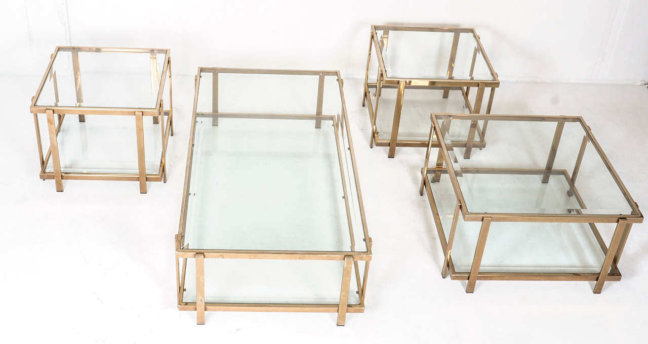 Beautiful Hollywood regency style 23 carat gold plated (marked on a tag) set of 4 tables. One rectangular table, one square and 2 smaller identical square tables. Original glass without chips and the gold is not at all faded
