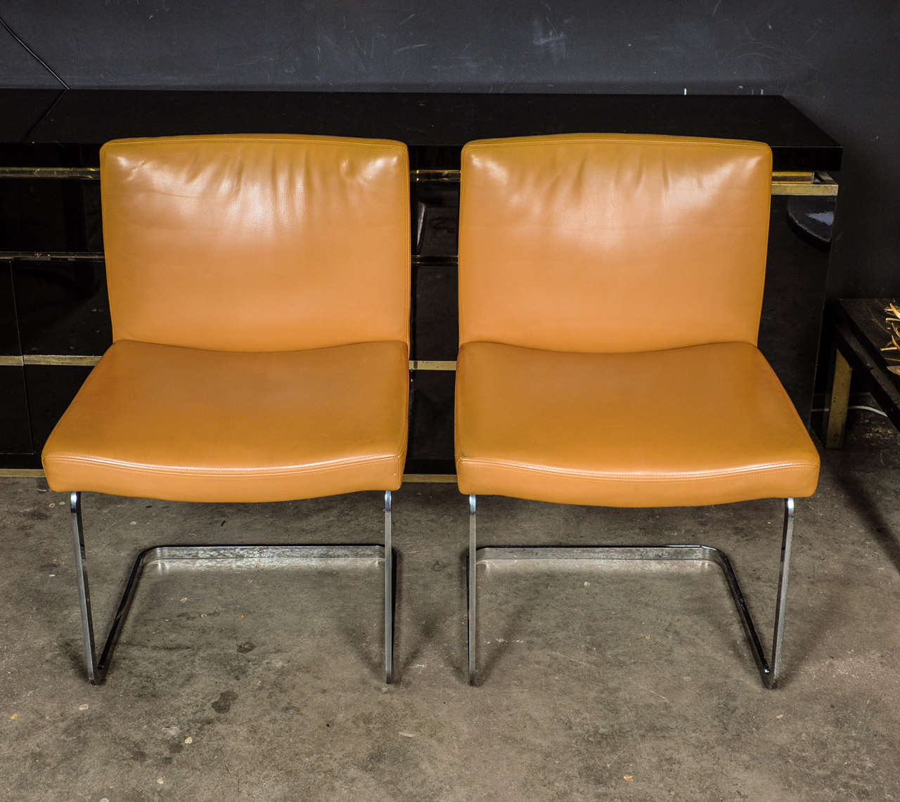 Unique and rarely available set of 8 dining room chairs designed by Jean-Pierre Dovat for Swiss top-end manufacturer De Sede. Beautiful tanned camel colored leather in as-if-new condition on an elegant chromed steel base. The chairs are in an