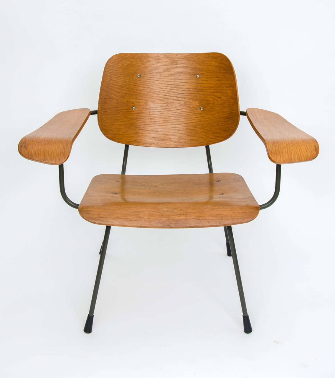 Bent ply lounge chair - model 8000 - by Tjerk Reijenga for Pilastro, Netherlands 1960s.

Rarely seen lounge chair with plywood seat and back panel screwed to a grey/brown steel frame. The striking sculptural form and compact size belie a very