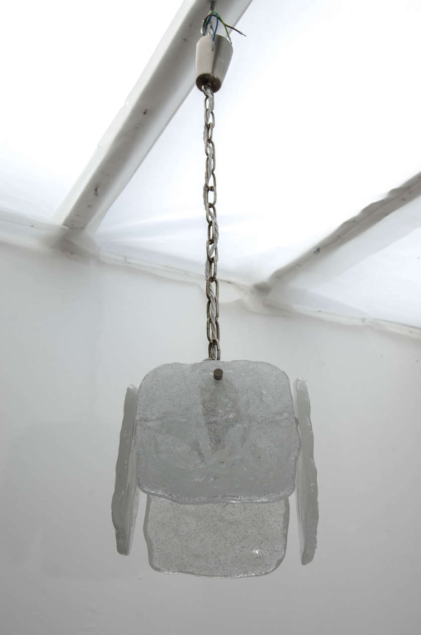 Pair of ice glass pendant lights by Kalmar, 1960s.

A pair of pendant lights each featuring four large squares of white, opaque textured glass. The lights are in very good condition. Due to the age of these pieces, there may be small imperfections