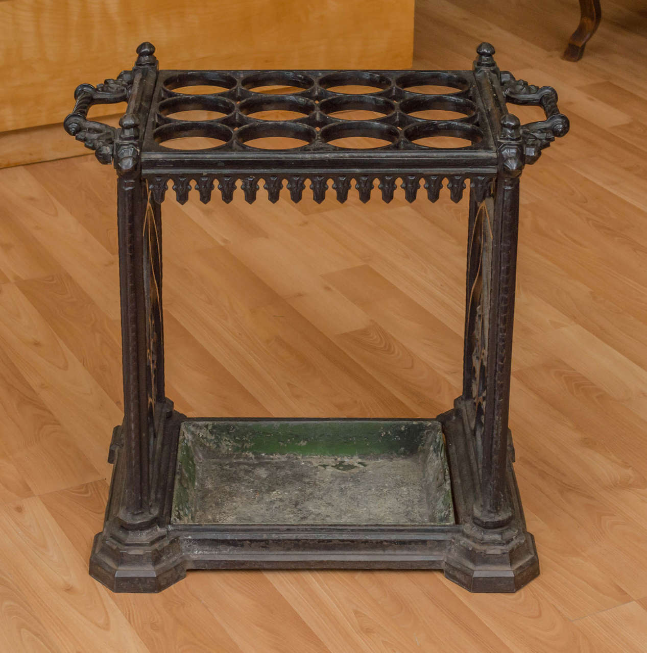 Gothic revival umbrella stand from Victorian England c1860s. Cast Iron with twelve apertures for umbrellas and/or canes/walking sticks. At it's bottom a removable drip tray.