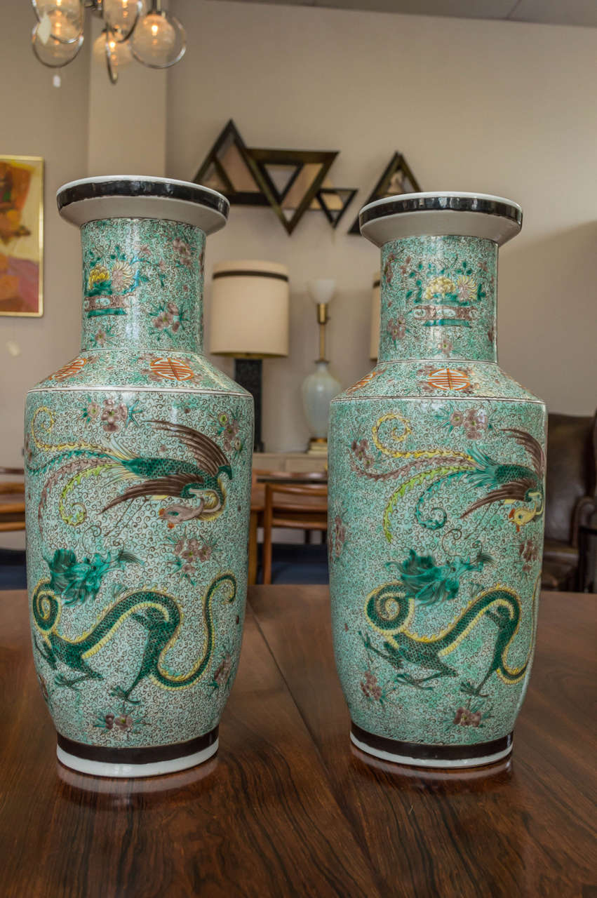 A wonderful pair of tall 19th century Qing Dynasty Chinese vases. Scenes on both side depicts a Dragon fighting a pheasant. They are both marked on their underside base, detailing on this hand painted porcelain vase is colorful and superb.