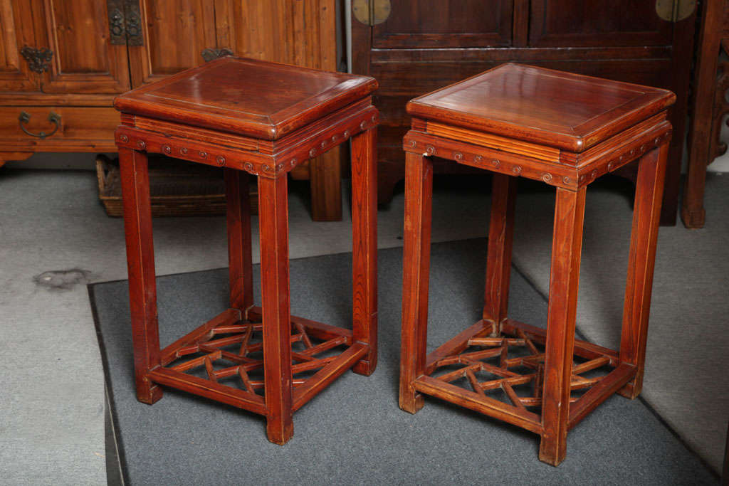 Pair of late Qing dynasty traditionally built elmwood pedestal tables from the second half of the 19th century with 'cracked ice' stretcher. These nicely detailed Chinese elmwood pedestal tables were born during the late Qing dynasty, circa 1870.