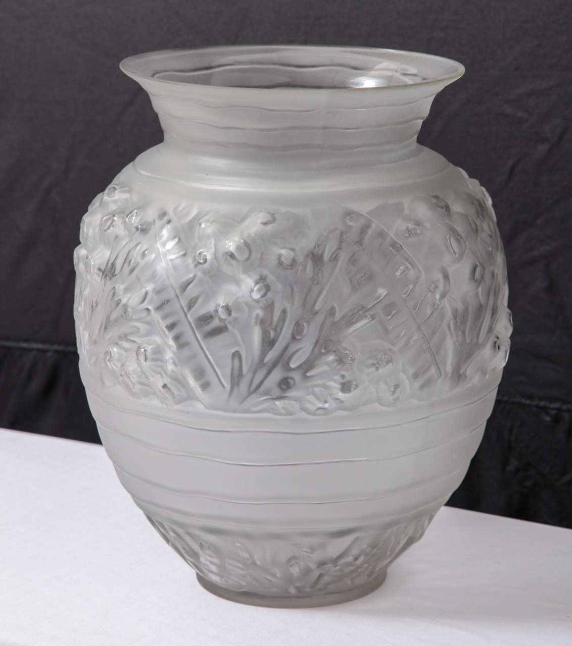 Signed by French designer Sabino.This Art Deco vase is composed of clear,opalescent glass molded with geometric flower reliefs.