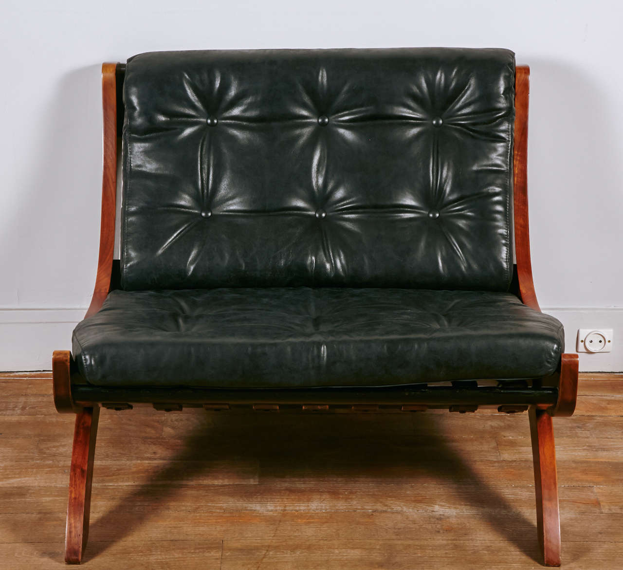 A rare pair of walnut slipper chairs 
upholstered with black leather cushions held by thick leather straps .
Designed by Marco Comolli , documented :  