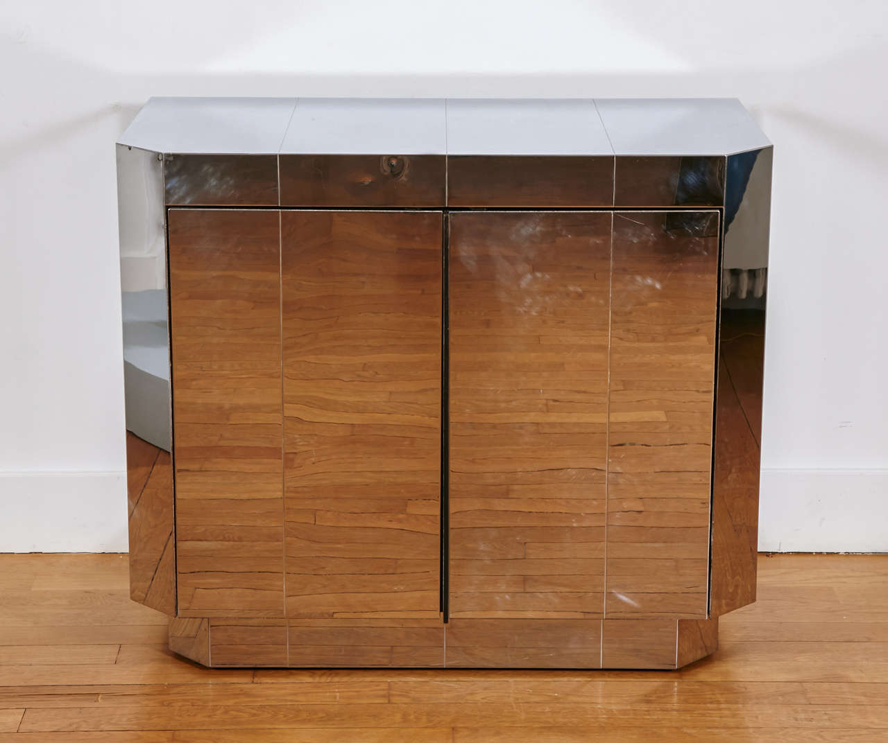 Cityscape cabinet, 1970’s, by Paul EVANS (USA, 1931-1987
Geometrical chromed steel plated work on wood structure. 
Opening with two doors on a black inside with shelf. 
Canted jambs. Plinth. Black back.

