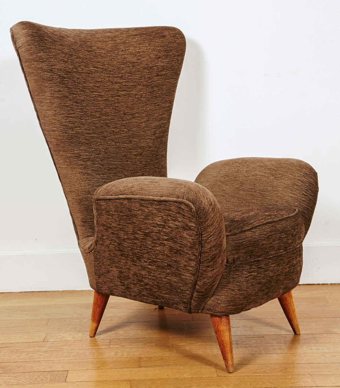 Pair of high armchairs, Italy, 1950's,
covered with their original brown velvet.
Triangle back, separated from the elbow leggers. 
4 oak conical feet.
(Darker Brown as on the pictures)