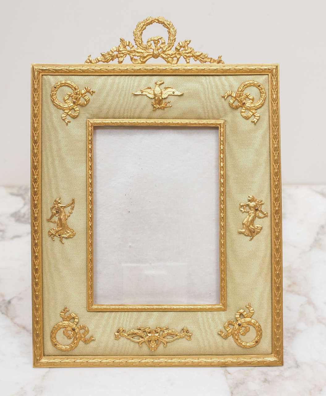 French Gilt Bronze Classically decorated frame applied to Moire Silk background.