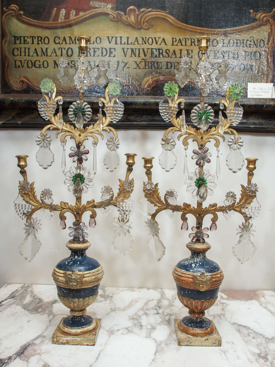 Pair of Italian Louis XVI Painted and Parcel Gilt Urns with putti head and fluted decoration surmounted with Crystal dressed Gilt Iron upper armature and bronze candle cups of later date, probably early 20th century additions for common taper