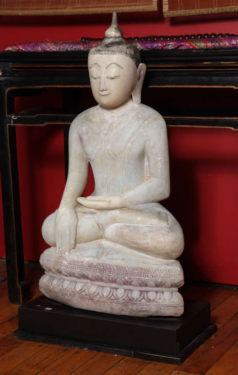 A Shan style Burmese Buddha alabaster sculpture from the 17th or 18th century on custom base. This Buddha sculpture, seated in the attitude of “calling the earth to witness” comes from Myanmar, where it was hand-carved from alabaster during the 17th