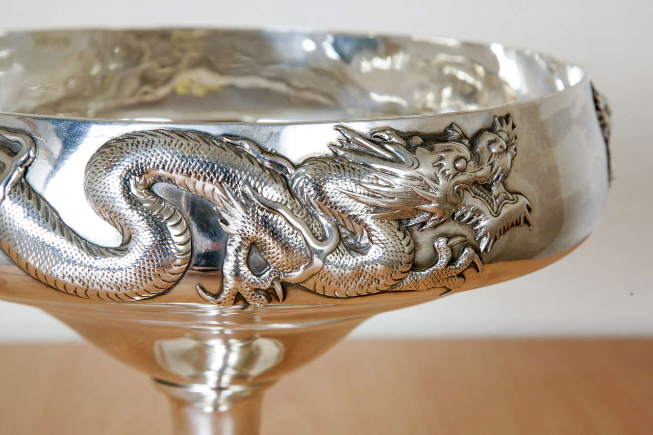 Chinese export silver bowl on plain round pedestal base. The decoration is of two applied opposing dragons against a plain background. The bowl was made by Luen Hing '联兴‘, Shanghai, circa 1900, and with the maker's mark is ‘铨’ (Quan). 
