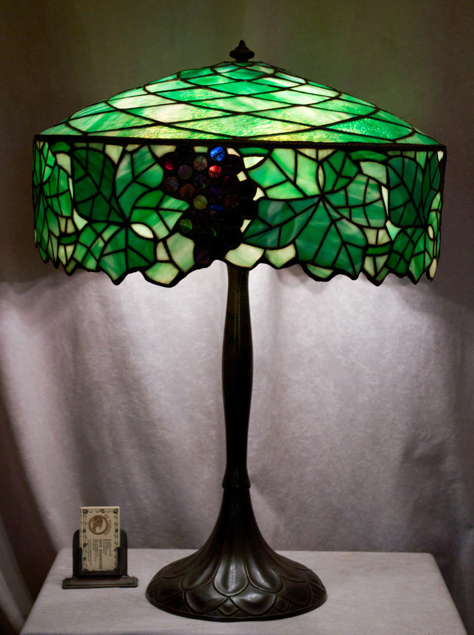 This extra large and well designed leaded glass lamp is signed on both the bronze base and the shade.  A similar model is pictured on page 139, top right, in the book, 