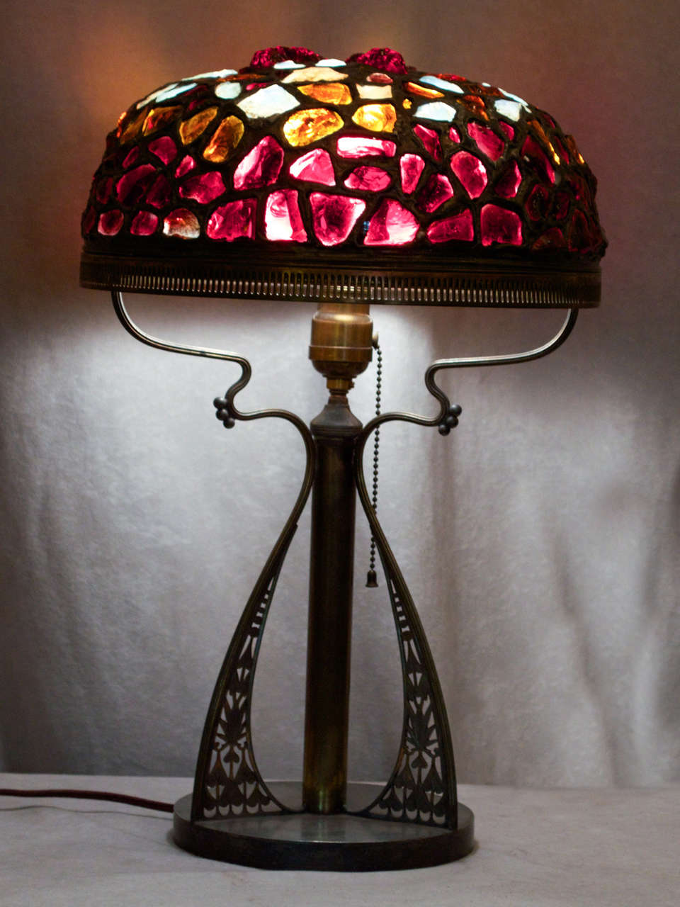 This colorful and exotic shade rests upon a base signed by the Pairpoint Company.  While we bought this lamp as you see it, as far as we know, Pairpoint did not make shades like this.  However, both base and shade are from the same period and the