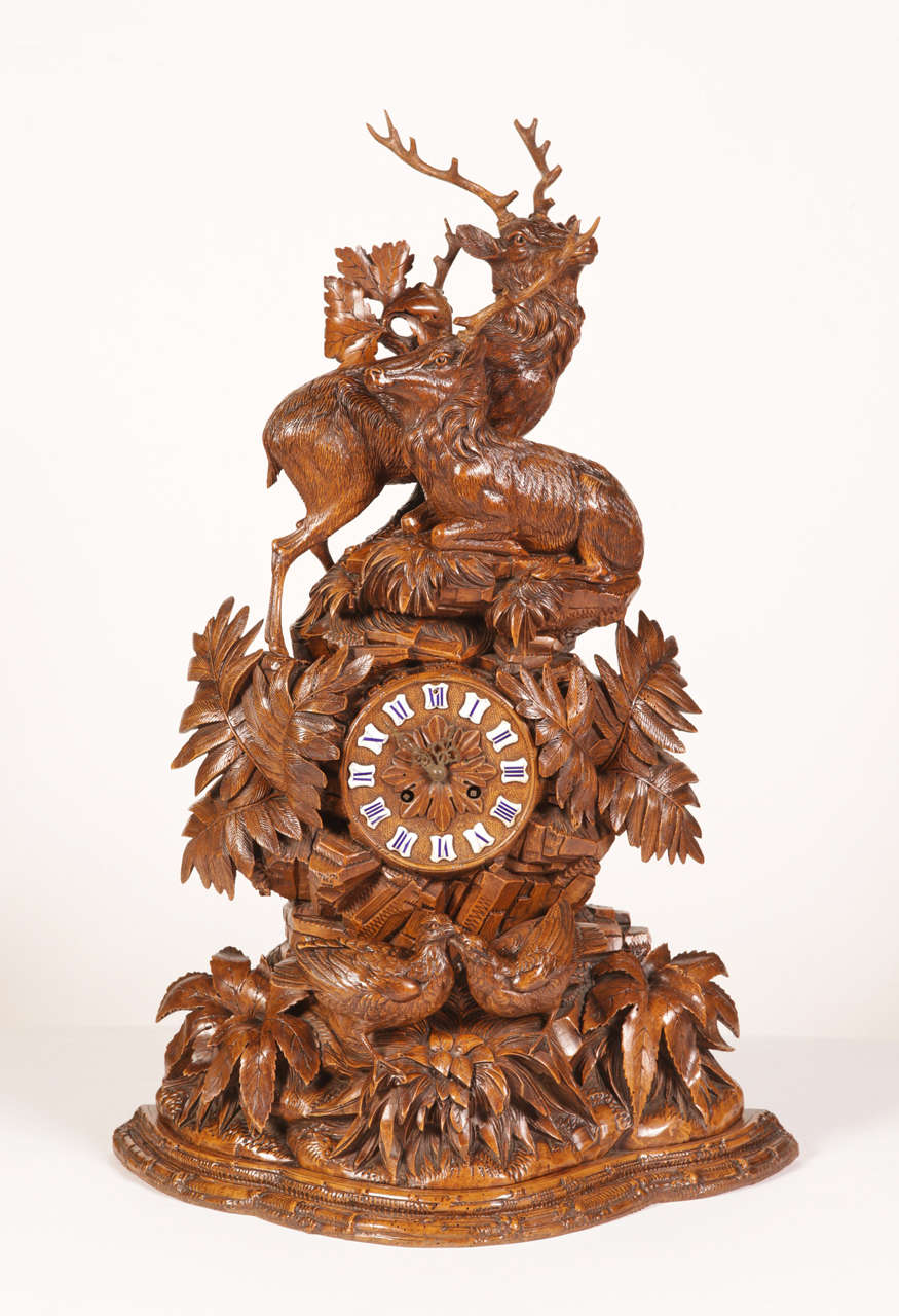Exquisite 19th century carved walnut black forest mantle clock featuring two stags, a couple of love birds and carved leaves throughout. The clock is in working condition with the original mechanism in place as well as authentic enamel roman