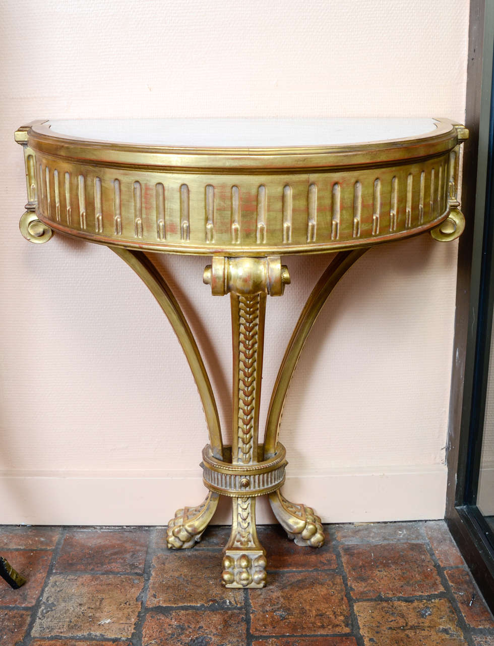 pair of gilded wood consoles with white marble top.