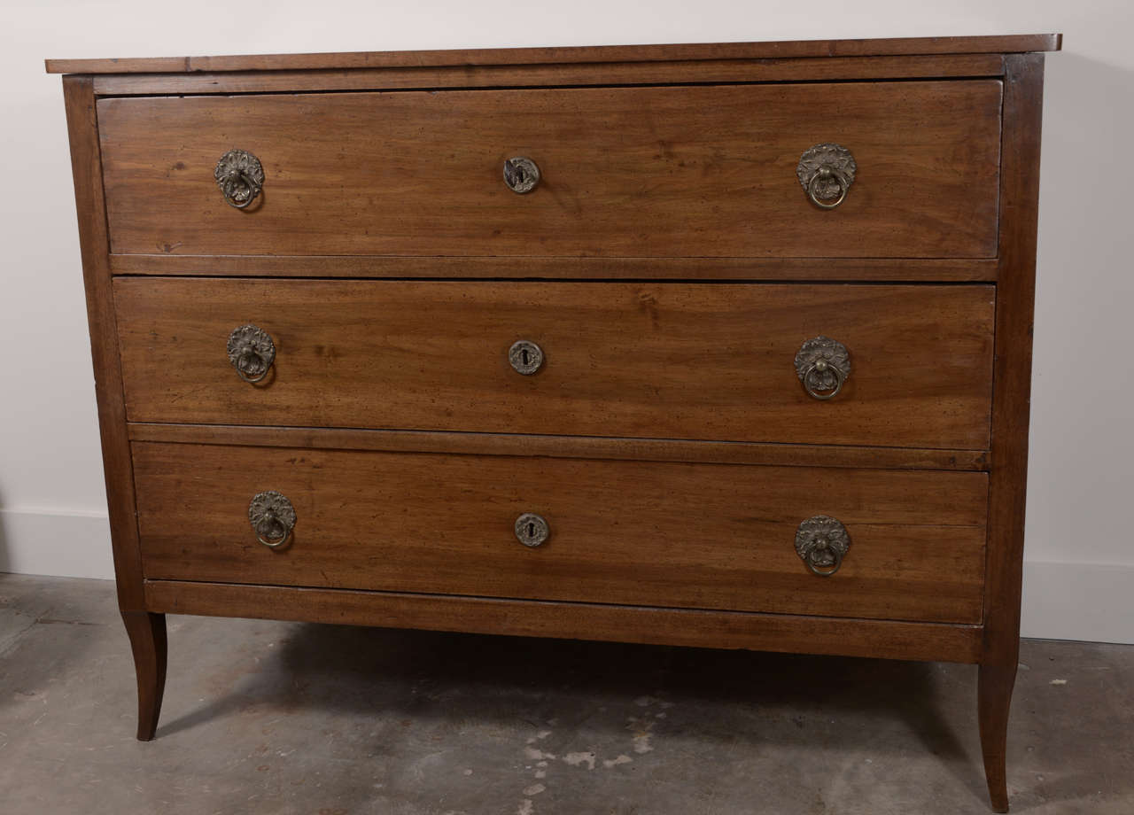 19th century Italian Directoire walnut commode with slightly tapered legs on all four sides, three drawers with original hardware and key. Beautiful patina.