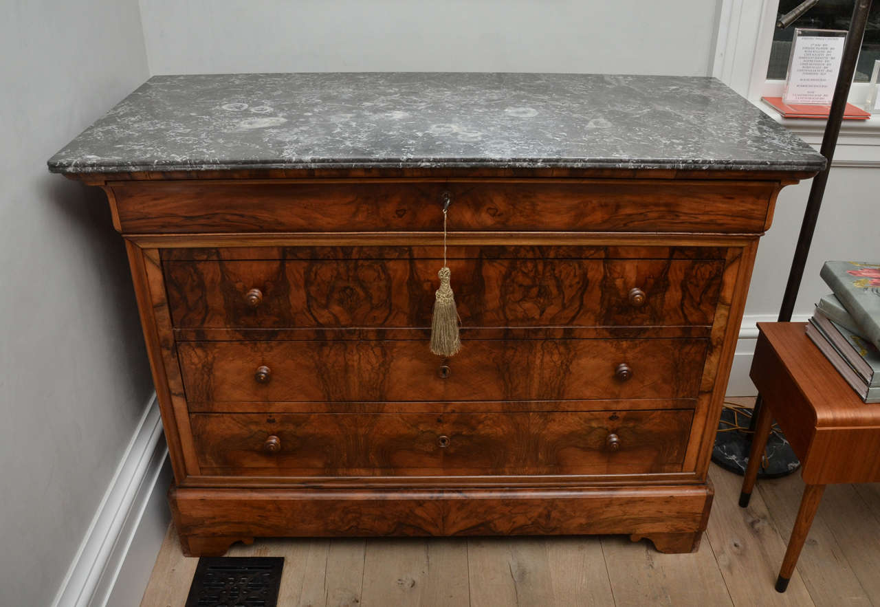 Stunning 19th Century French Louis Philippe Period Commode in Walnut  with Original Black Marble Top. Three Wide Drawers and One Cutlery and Napkin Drawer allow for maximum storage.