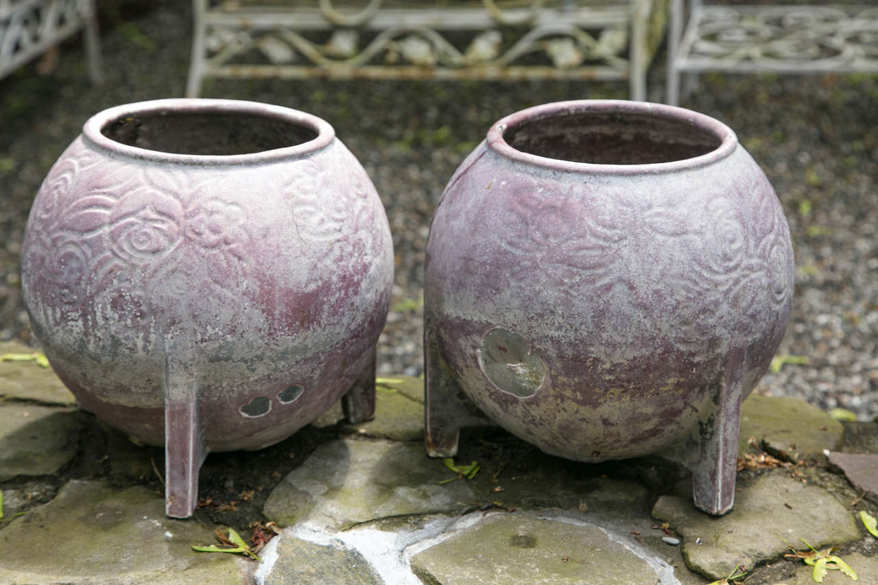 A pair of unique round cast iron jardinieres attributed to Deville & Cie of Charleville, France. The casting has a floral detail. There is drainage below for permanent planting.