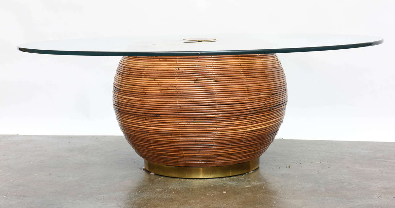 Very chic pencil reed wrapped cocktail table with brass accents.