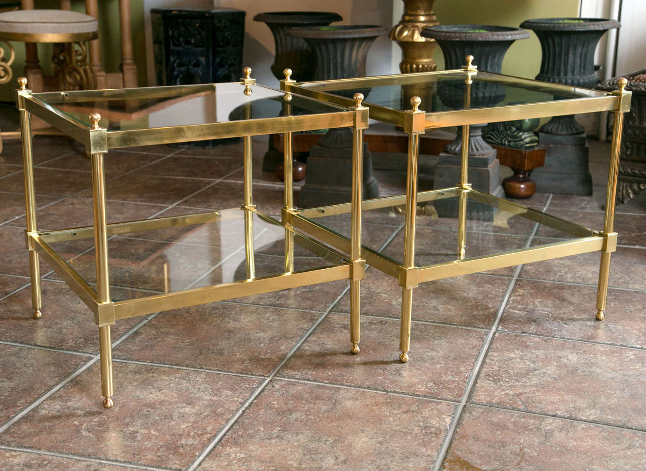 Pair of square brass two tier tables having glass top and lower glass shelf all raised on a straight leg