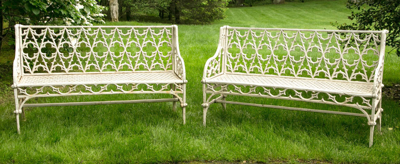 Pair of gothic style cast iron benches having tracery decorated back and honeycomb seat