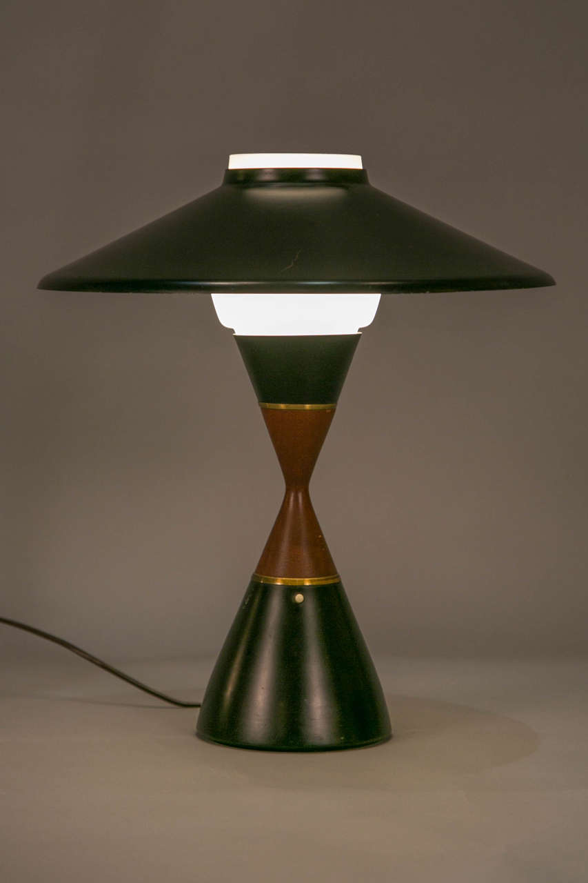 Elegant blackened metal and mahogany diabolo table lamp, circa 1958, by Svend Aage Holm Sorensen (Denmark 1913 – 2004).
With an opaline glass under a black reflector.

Sorensen was an important Danish lighting designer. This model was once made