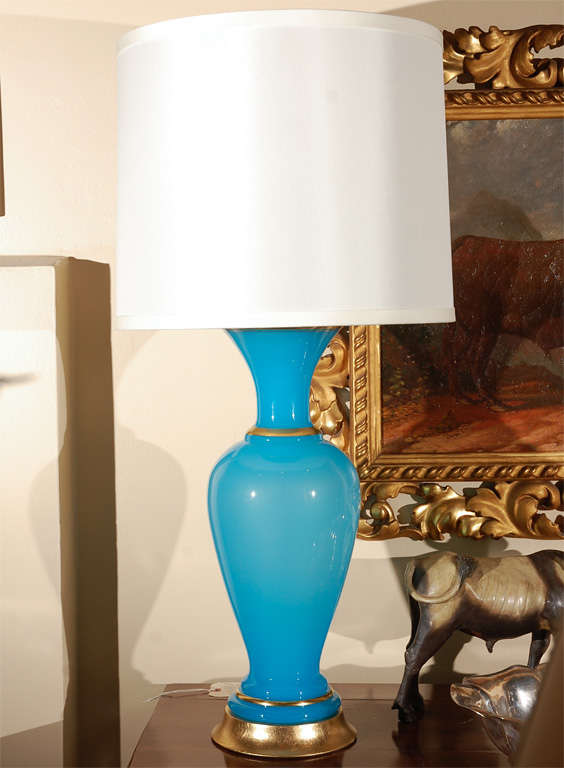 Pair of vibrant, French Opaline lamps in blue. Both with gilt metal bands on the feet and necks. Mounted on giltwood bases.