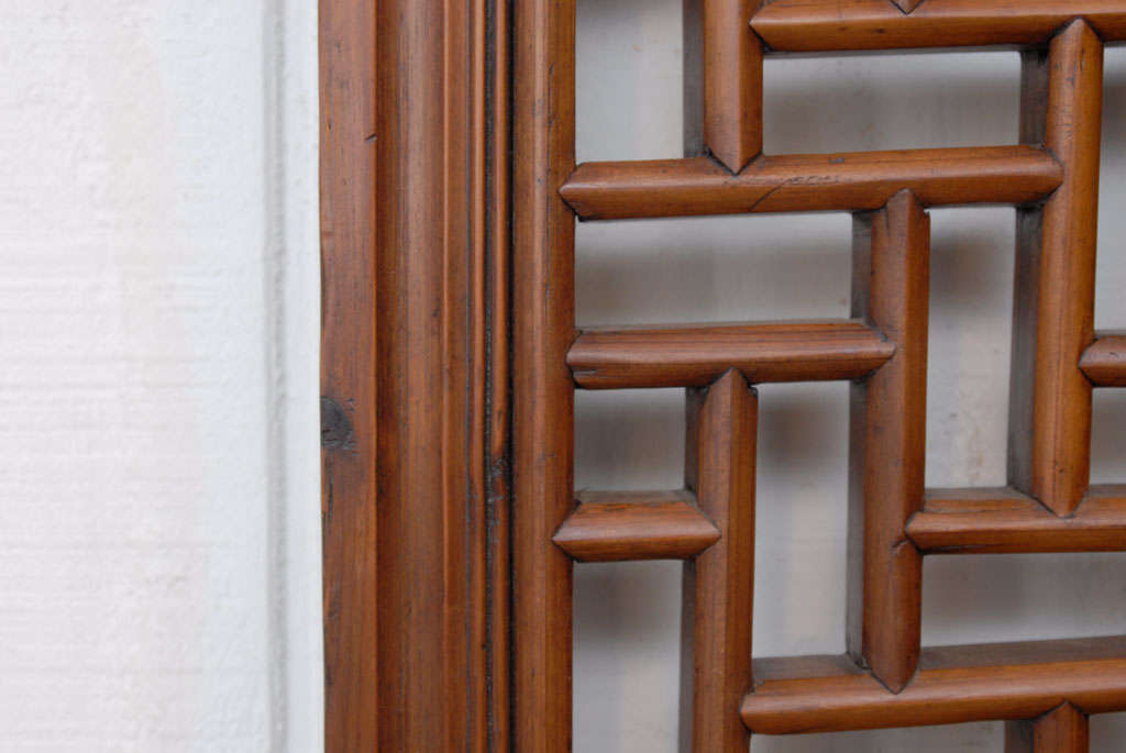 Elegant geometric fretwork Chinese elmwood window panel with decorative bronze hooks for hanging. A beautiful architectural wall hanging/decoration or small screen.