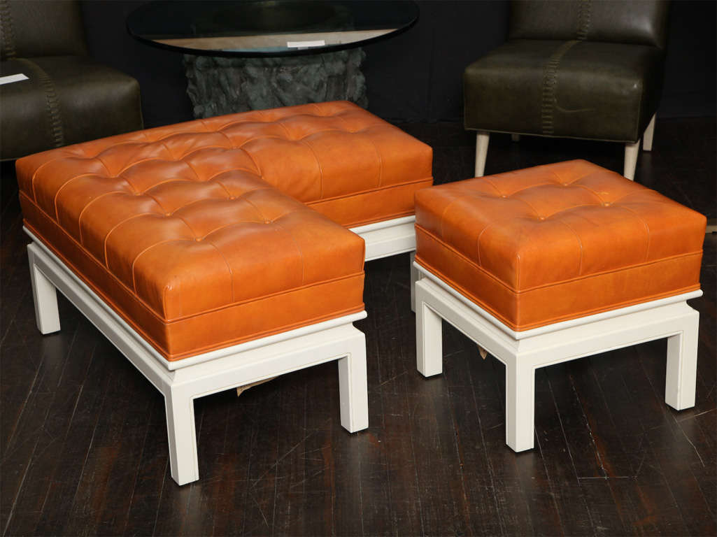 Unusual form with turned wood base, painted in off white.  Tufted top upholstered in burnt-orange leather.  Very striking concept with one small square piece, nesting into the larger L-shaped portion.  *To see our entire inventory, go to