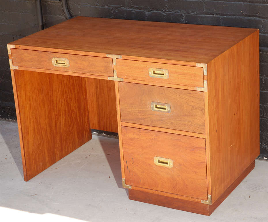 Solid wood 4-Drawer desk featuring campaign style brass corner drawer pull accents.