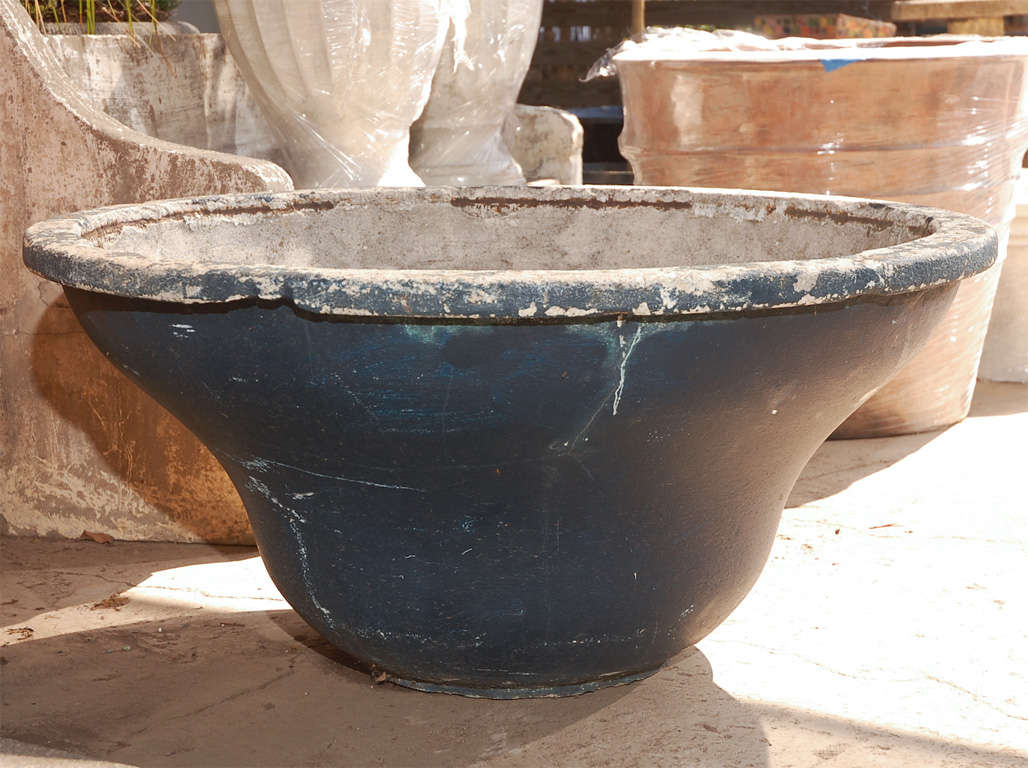 French round cast concrete planter with residual black paint.