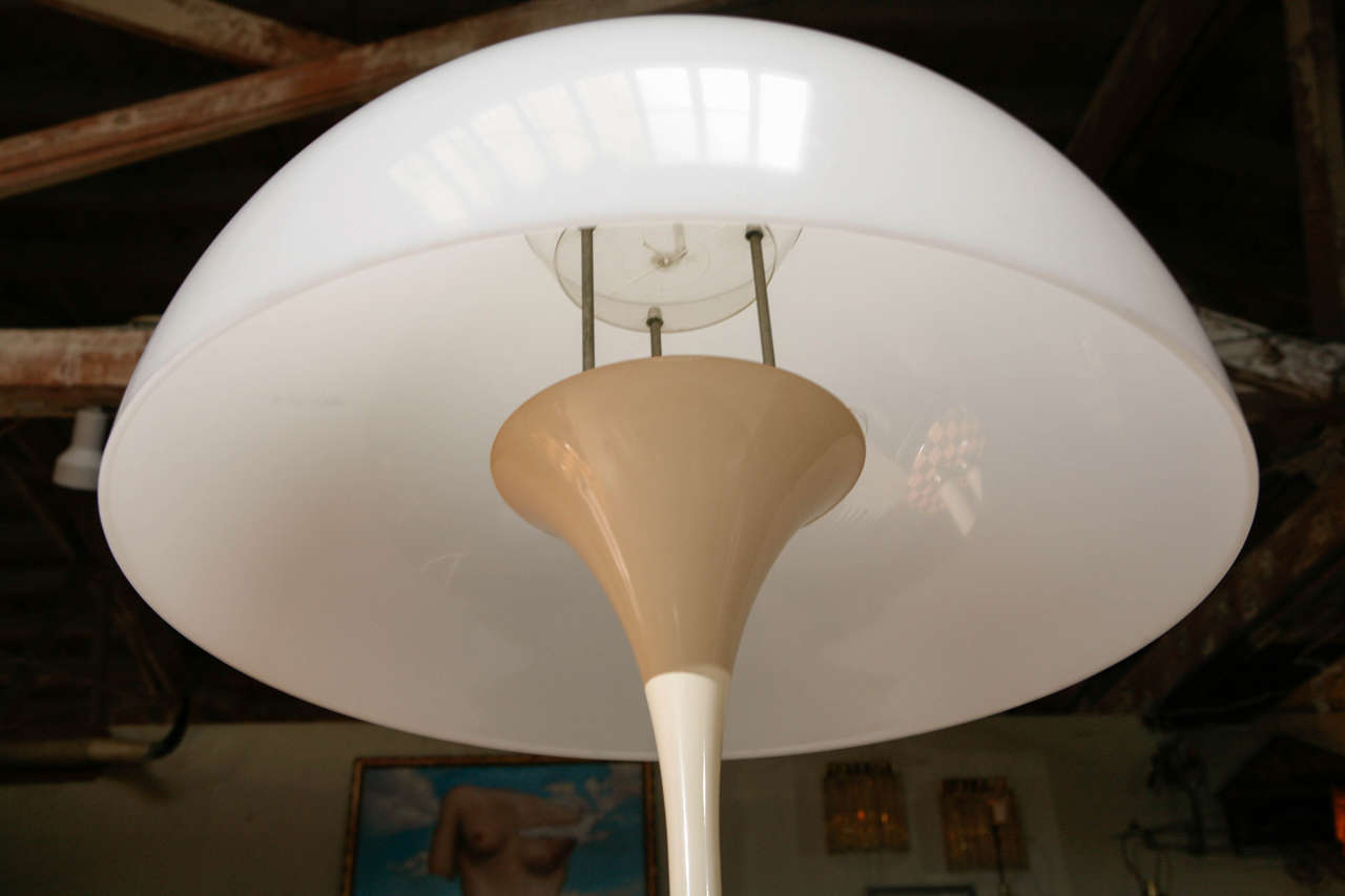 A vintage Verner Panton Floor Lamp in white Lucite, plastic and white enameled metal. Shade sits on a metal point that balances on a piece of plastic above the bulb.