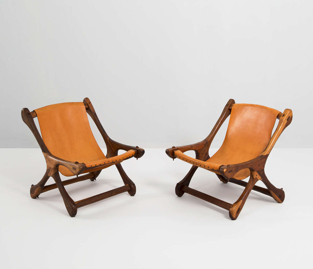 Pair of sling lounge chairs, in rosewood and leather, by Don Shoemaker, Mexico 1960s. 

Very nice and interesting set of 2 winger sling chairs in cognac leather with a magnificent patina by Don Shoemaker for Senal furniture mexico. The Sling