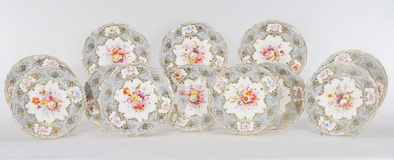 This is a gorgeous set of 12 hand painted dinner plates, artist signed by F. Howard. What makes these unusual is the wonderful dove gray border, embellished with gold enamel. Each plate is uniquely decorated with sprays of flower specimens