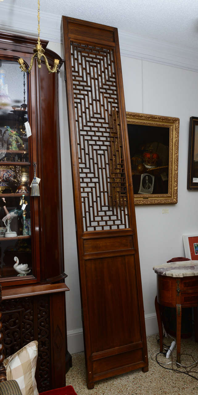 A very unique Chinese folding screen that is hinged so that it stand alone as a single panel or multiple units depending on your design needs.  Fretwork upper panel with two flat panels beneath.  Original restored finish. Each panel is 22