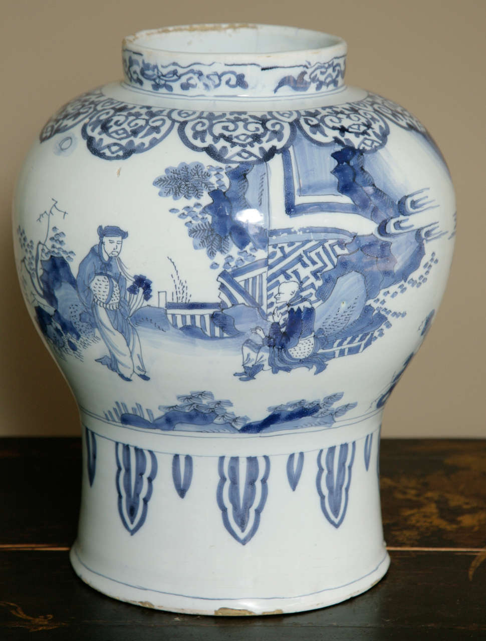 Large Dutch delft baluster vase, circa 1680, decorated in the Chinese transitional style with figurative scenes of scholars and officials with an attendant in a landscape of rockwork and trees, beneath a border of lappets, all above a border at the