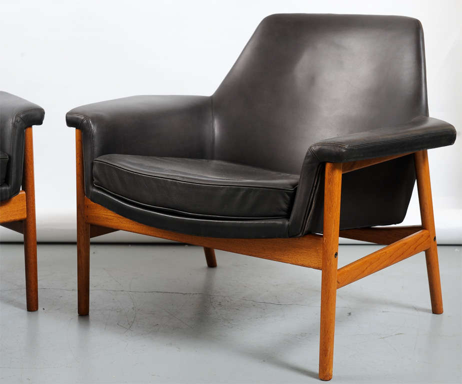 Ib Kofod Larsen easy chair. This chair is a rare variation of the Seal chair and produced for a limited period. Produced by OPE. Upholstered with black leather, teak frame. Priced individually, two available.