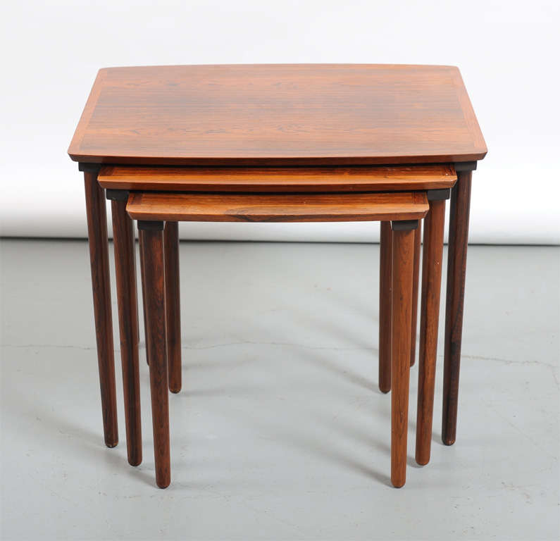 A set of three nesting tables made of rosewood with a fitted slot on each table holding them all together. Made by Mobelintarsia of Denmark.