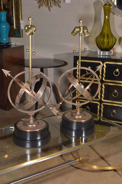 Pair of bronze Zodiac lamps on newly refinished black lacquered wood stacked bases. Rewired with double cluster on/off pull chains with French style rayon cords. Marked 