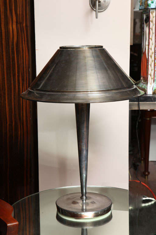 Jean Perzel.
Lampe de table en métal chromé, vers 1930, dissimulant un abat-jour en verre dépoli en forme de cloche inversée, la base portant l'inscription Perzel.
Mesures : Hauteur 22 in (55,8cm) ; diamètre 16 ¼ in (41,2cm).