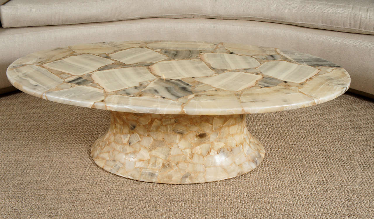 Here is an elegant oval marble top coffee table with a curved resin and marble base.