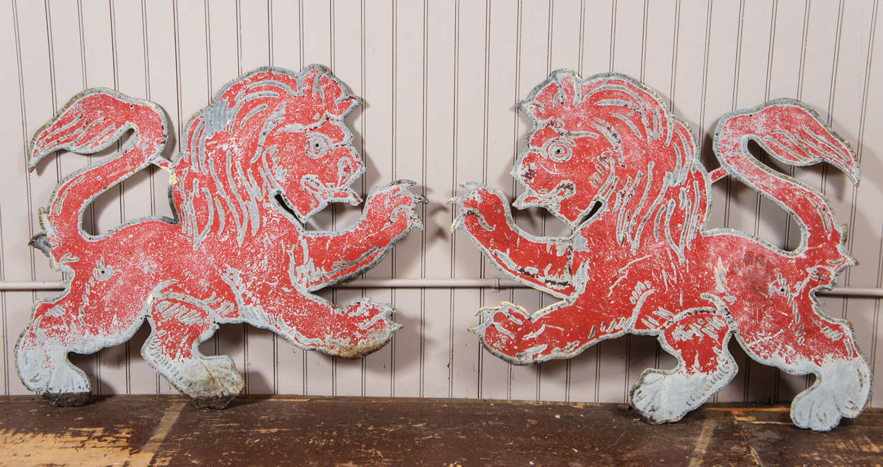 pair of quarter inch thick metal lions - raised metal detailing - in red  distressed painted surface - originally from The Red Lion Inn of Stockbridge, Mass.