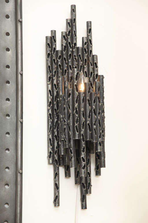 A pair of sculptural, handcrafted wall sconces in the Brutalist style, produced circa 1960s in Italy, crafted of patinated iron.