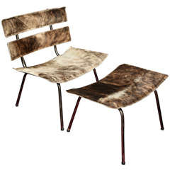 A set of cow hide and chrome chair and ottoman