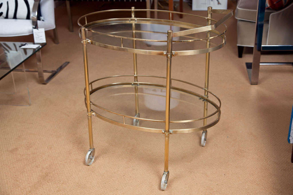 Mid century brass oval bar cart, 2 tiers with gallery rails and glass tops.