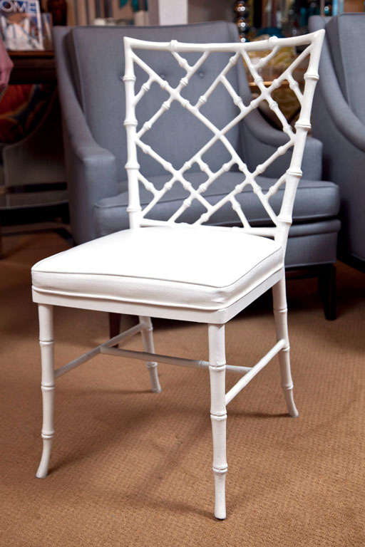 Nice set of white painted faux bamboo metal chairs. Chinese Chippendale style fretwork backs and new ivory faux ostrich upholstery.