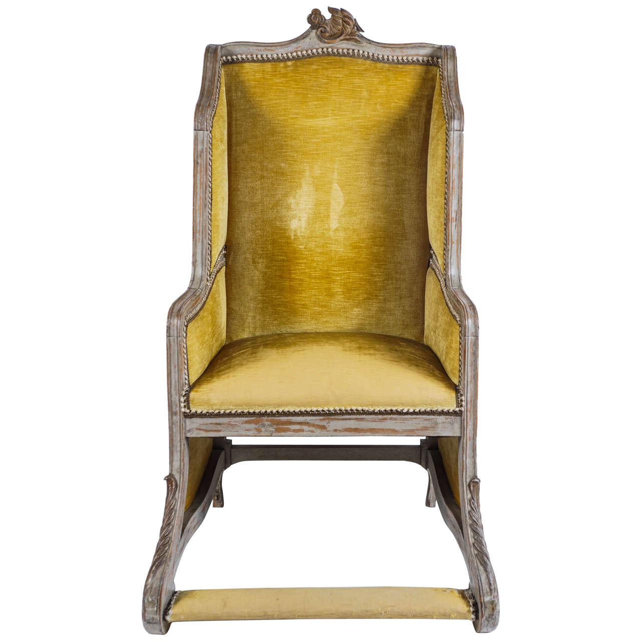 A rare French Louis XV style carved and painted bergere having crest-rail with center carved rococo foliate motif and paneled upholstered sides, back, and seat with upholstered integral footrest joined by foliate scroll form supports.  This chair
